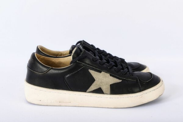 Zwarte sneakers met sterdecoratie.